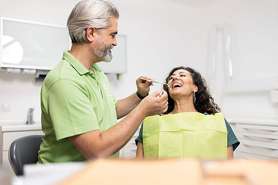 Zahnarzt kontrolliert Zähne der Patientin